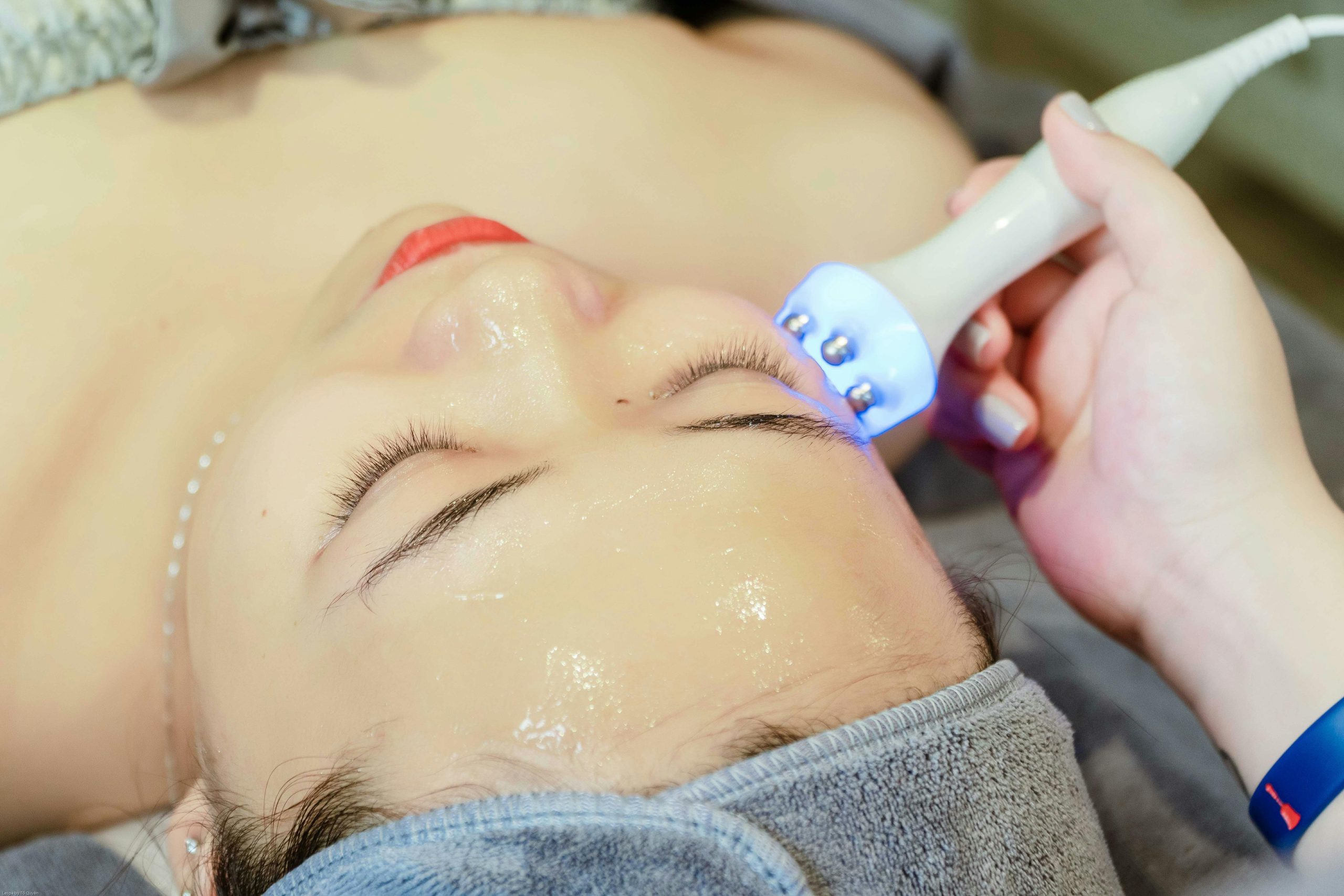 Close-up of a woman receiving an ultrasonic facial treatment in a spa in Hanoi, Vietnam.