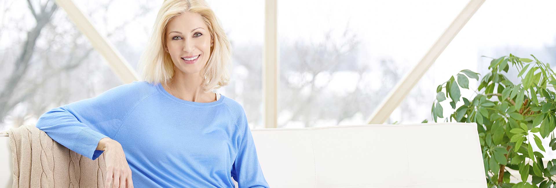 Beautiful middle-aged woman relaxing on the sofa at home