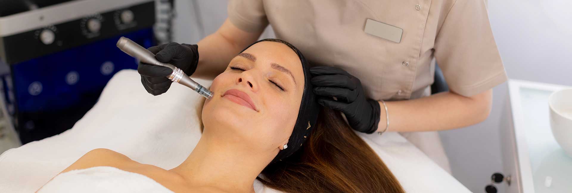 A skilled practitioner uses a microneedling mesotherapy device to rejuvenate a client's skin